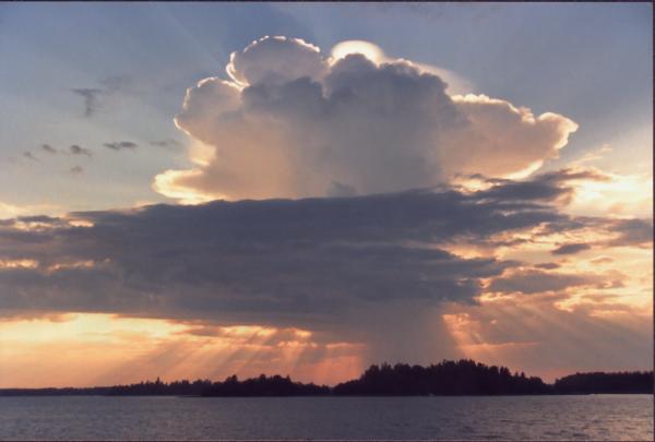 Rays of light is shooting out from behind a large mushroom shaped cloud over the bay of Storviken in Vasa